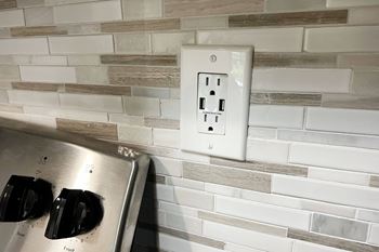 an electrical outlet on a brick wall in a kitchen at Deercross Apartments, Cincinnati